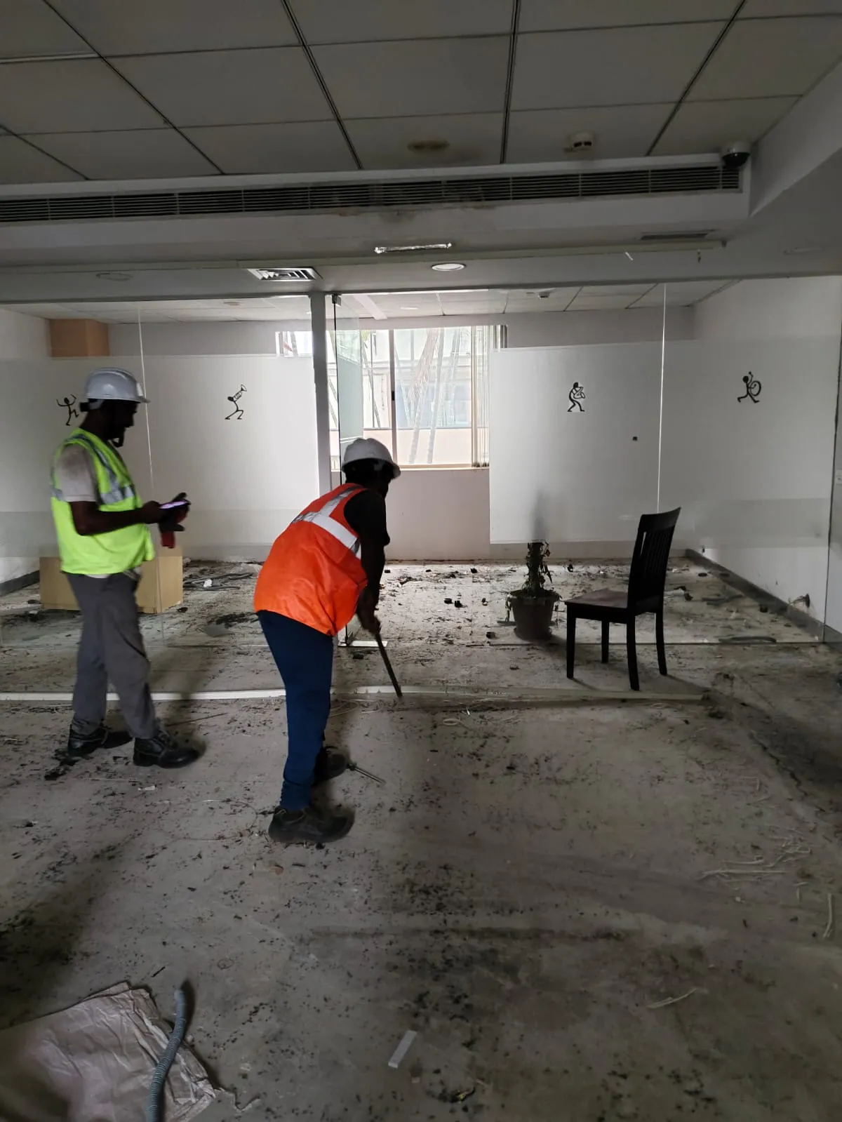 Deconstruction technicians dismantling linear workspace frames safely inside a high-rise office building along Perungudi OMR Chennai.